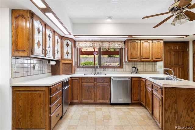4 Pine Rd, Colorado Springs, CO 80906 - kitchen featuring dishwasher, a sink, brown cabinets, a peninsula, and a textured ceiling