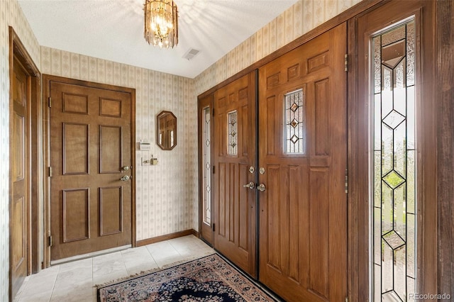 4 Pine Rd, Colorado Springs, CO 80906 - entryway with wallpapered walls, a chandelier, baseboards, and light tile patterned floors