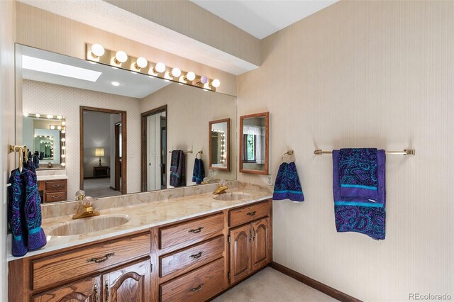 4 Pine Rd, Colorado Springs, CO 80906 - full bathroom featuring double vanity, a skylight, and baseboards