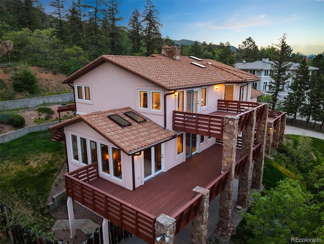 4 Pine Rd, Colorado Springs, CO 80906 - rear view of house with a chimney, a deck, stucco siding, and a tile roof