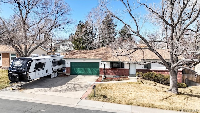 ranch-style home with driveway, brick siding, an attached garage, and fence