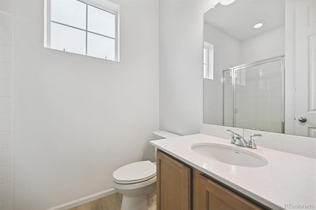 bathroom featuring vanity, hardwood / wood-style flooring, toilet, and an enclosed shower