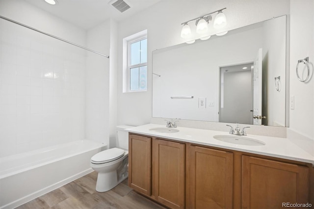 full bathroom with hardwood / wood-style floors, vanity, toilet, and shower / bath combination