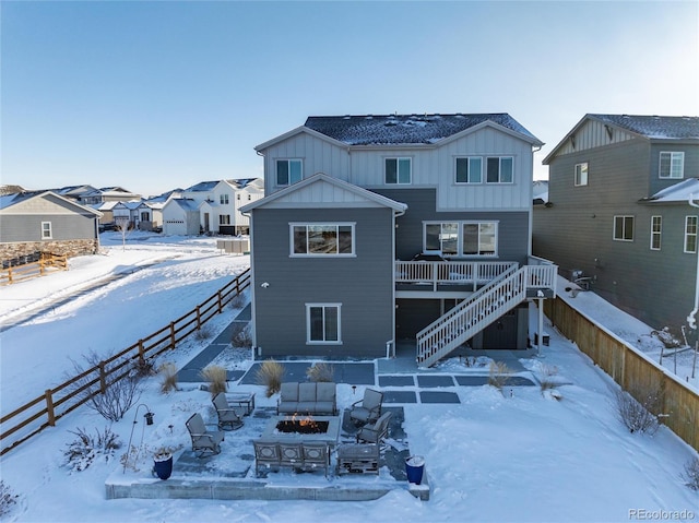 snow covered property featuring a wooden deck and an outdoor fire pit