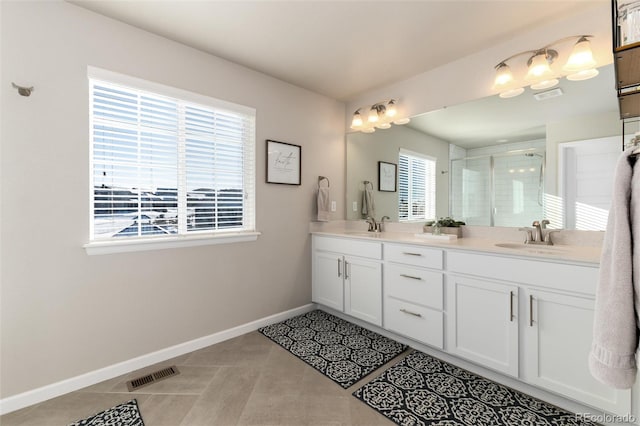 bathroom featuring an enclosed shower, a healthy amount of sunlight, tile patterned flooring, and vanity