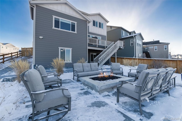 snow covered back of property with a fire pit