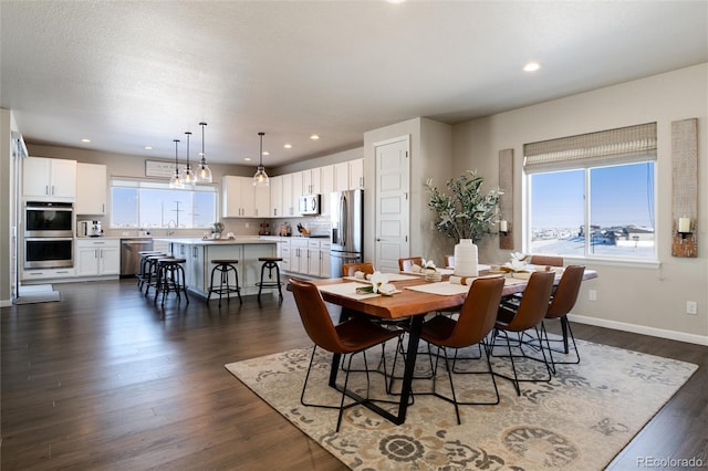 dining area with a healthy amount of sunlight and dark hardwood / wood-style floors