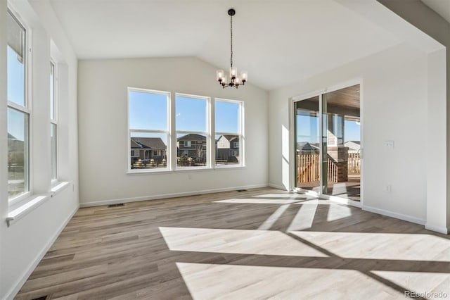 unfurnished room with lofted ceiling, light wood-type flooring, and a chandelier