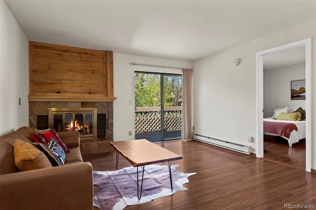 living area with baseboard heating, wood finished floors, and a fireplace