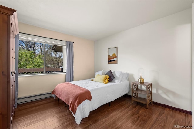 bedroom featuring baseboard heating and wood finished floors