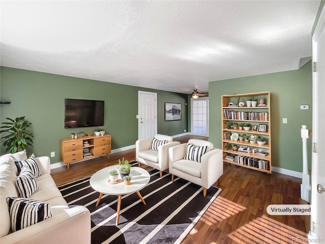 living room featuring ceiling fan, dark hardwood / wood-style floors, and a textured ceiling