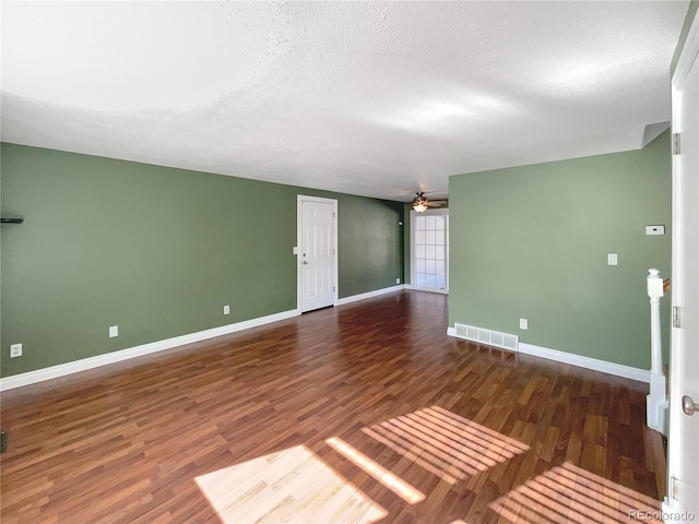 empty room featuring dark hardwood / wood-style flooring, a textured ceiling, and ceiling fan