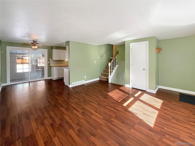 unfurnished living room with dark hardwood / wood-style floors and a textured ceiling