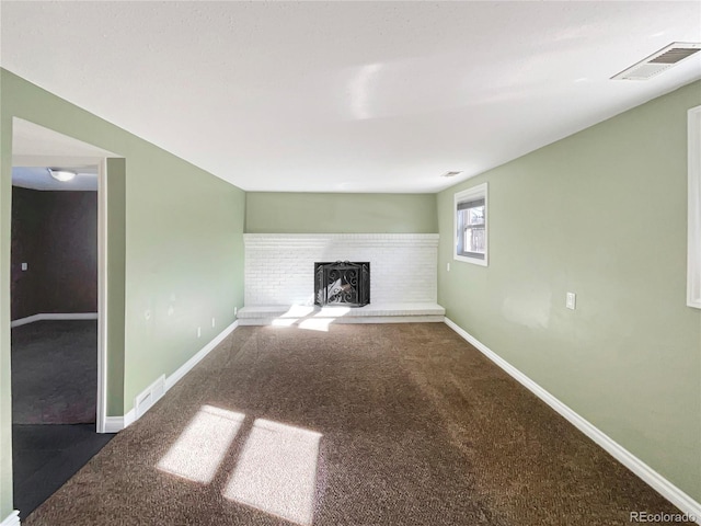 unfurnished living room with a fireplace and dark carpet