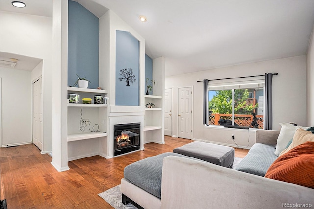 4220 E 119th Pl Unit A, Thornton, CO 80233 - living area with wood finished floors, a glass covered fireplace, vaulted ceiling, and built in features