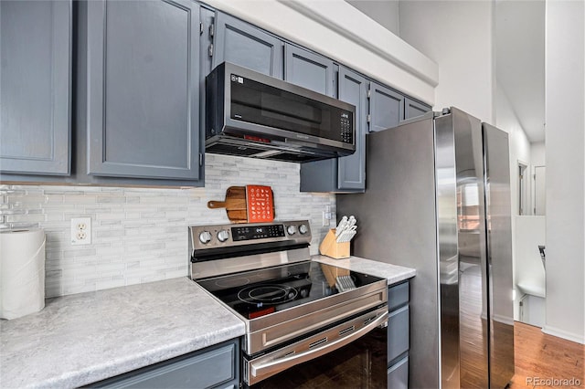 4220 E 119th Pl Unit A, Thornton, CO 80233 - kitchen featuring appliances with stainless steel finishes, light countertops, gray cabinetry, and tasteful backsplash