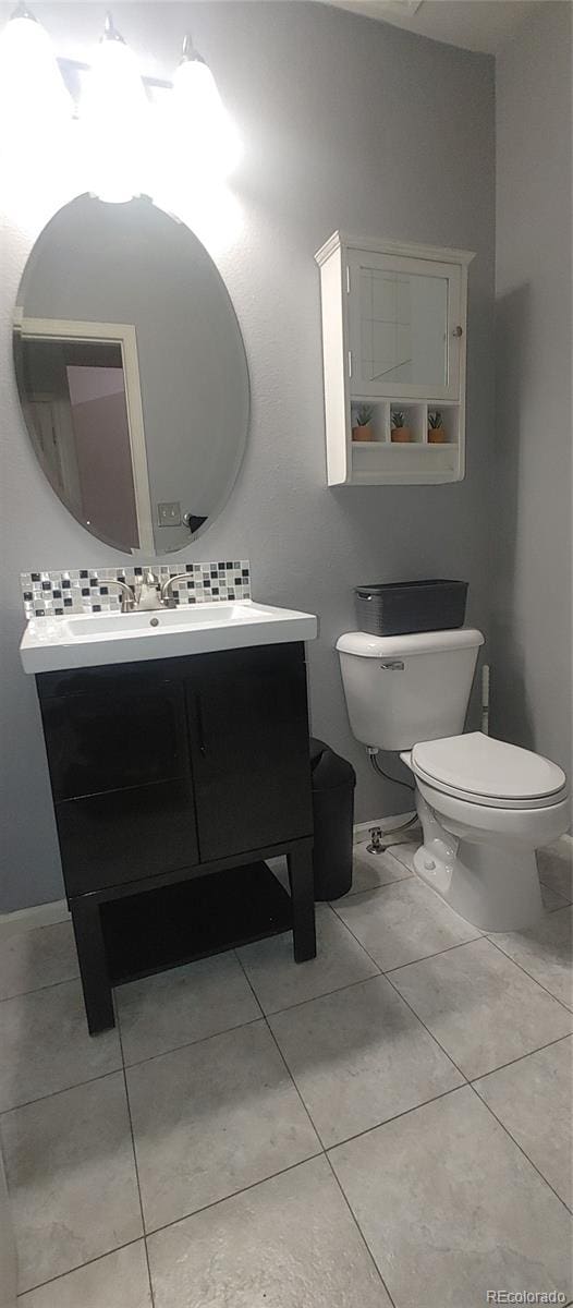 4220 E 119th Pl Unit A, Thornton, CO 80233 - half bath featuring vanity, tile patterned floors, and tasteful backsplash