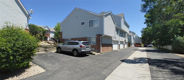 4220 E 119th Pl Unit A, Thornton, CO 80233 - view of side of home featuring brick siding and a residential view