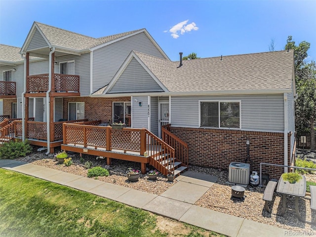 4220 E 119th Pl Unit A, Thornton, CO 80233 - view of front facade featuring brick siding, a deck, and roof with shingles