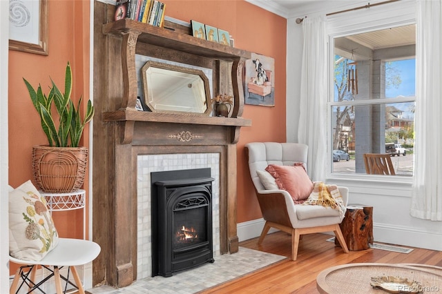 3059 N Humboldt St, Denver, CO 80205 - sitting room featuring wood finished floors, baseboards, a tiled fireplace, and ornamental molding
