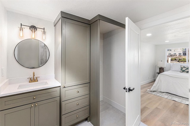 3800 W Eisenhower Blvd, Loveland, CO 80537 - bathroom featuring a textured ceiling, wood finished floors, ensuite bath, and baseboards
