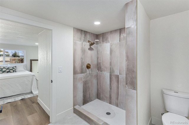 3800 W Eisenhower Blvd, Loveland, CO 80537 - bathroom featuring a tile shower, ensuite bathroom, toilet, wood finished floors, and baseboards