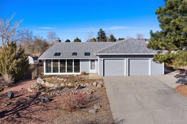 view of front facade featuring concrete driveway, a shingled roof, and an attached garage