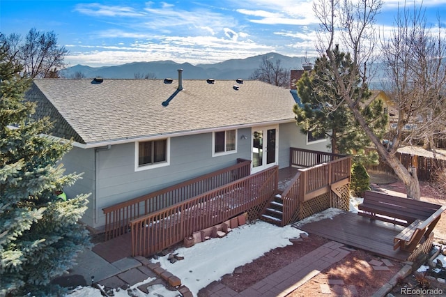 view of front facade featuring a deck with mountain view and a shingled roof