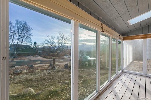 unfurnished sunroom featuring lofted ceiling with skylight