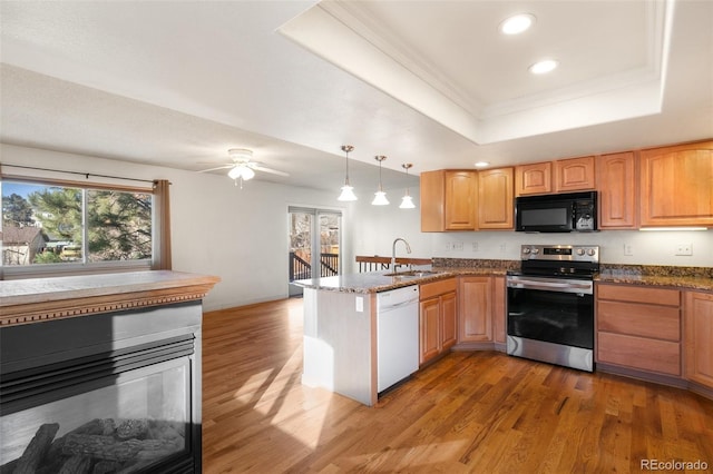 kitchen featuring a raised ceiling, a peninsula, white dishwasher, stainless steel range with electric stovetop, and black microwave