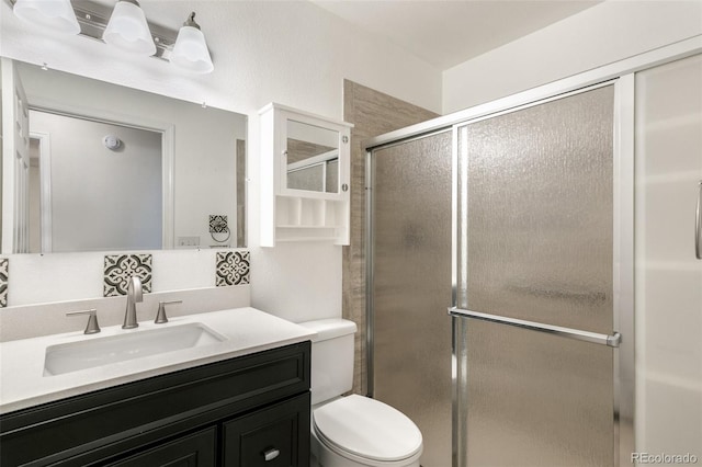 full bathroom with a shower stall, toilet, and vanity