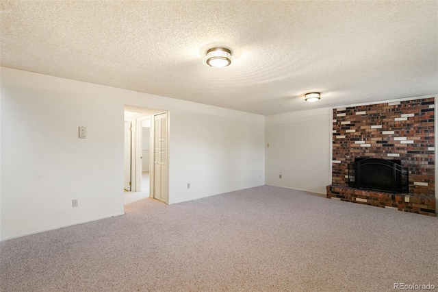 unfurnished living room with carpet flooring, a fireplace, and a textured ceiling