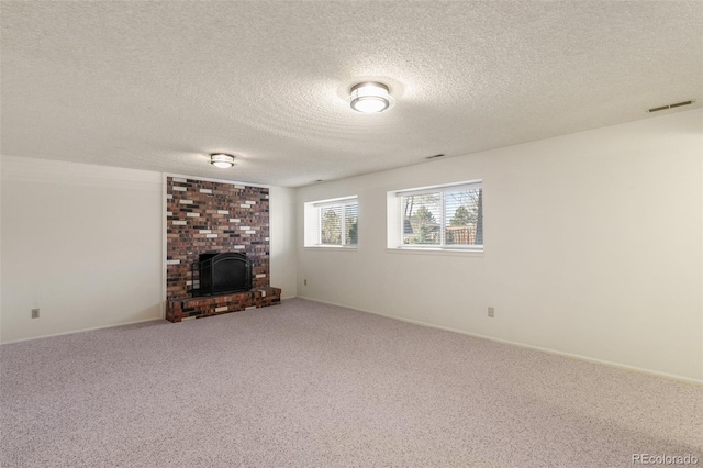 unfurnished living room featuring carpet, a textured ceiling, a fireplace, and visible vents