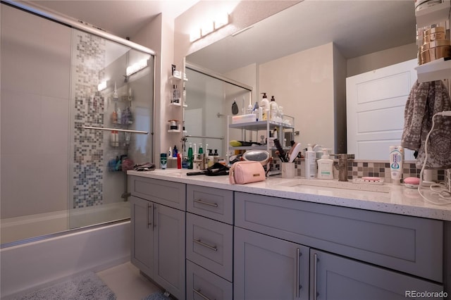 bathroom featuring shower / bath combination with glass door, vanity, and tasteful backsplash