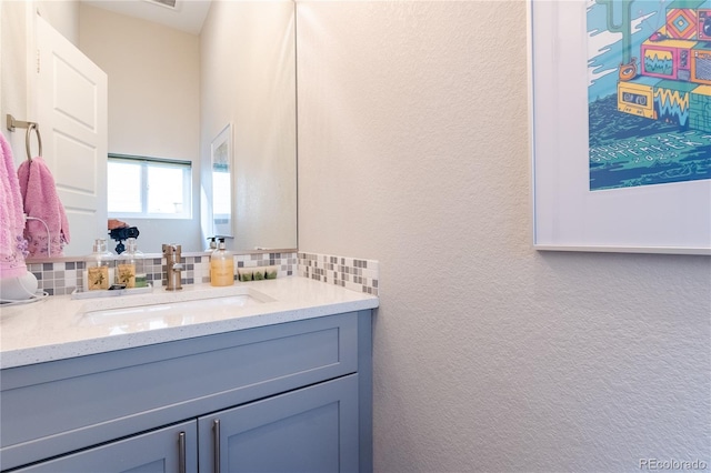 bathroom with vanity and tasteful backsplash