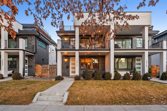 view of front of property with a front lawn and a balcony