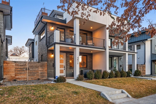 contemporary home featuring a yard and a balcony