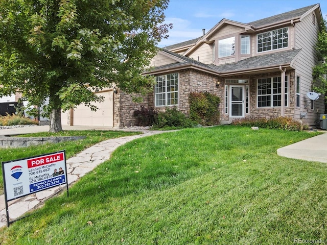 view of front of home with a front yard and a garage