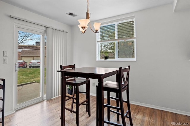 3021 S Ursula Cir Unit 102, Aurora, CO 80014 - dining room featuring a chandelier, wood finished floors, and baseboards