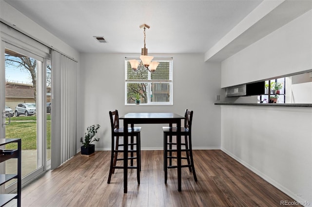 3021 S Ursula Cir Unit 102, Aurora, CO 80014 - dining room with wood finished floors, a chandelier, and baseboards