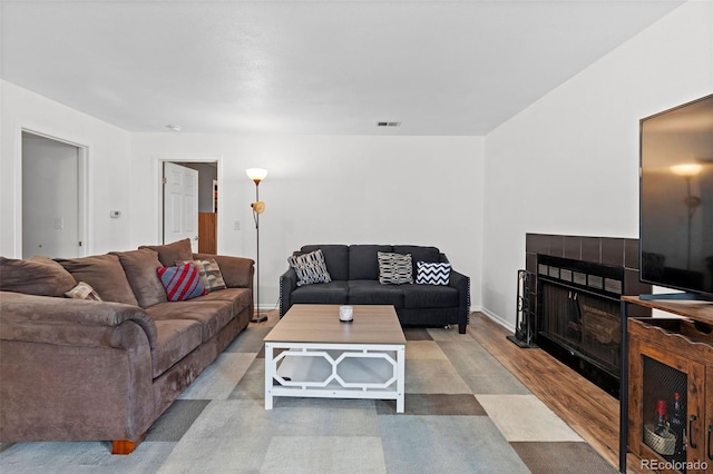 3021 S Ursula Cir Unit 102, Aurora, CO 80014 - living area with wood finished floors, a tiled fireplace, and baseboards
