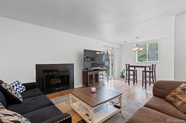 3021 S Ursula Cir Unit 102, Aurora, CO 80014 - living room featuring a chandelier, wood finished floors, and a fireplace