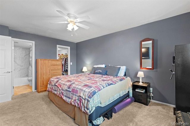 3021 S Ursula Cir Unit 102, Aurora, CO 80014 - carpeted bedroom featuring a spacious closet, a closet, ensuite bath, baseboards, and a ceiling fan