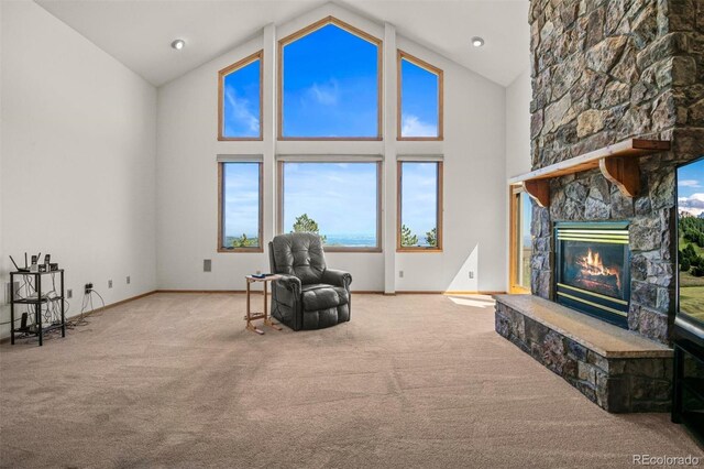 living area with a stone fireplace, light carpet, and high vaulted ceiling