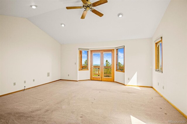 empty room featuring ceiling fan, light carpet, and vaulted ceiling