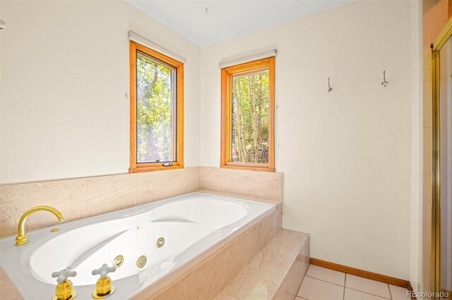 bathroom featuring tile patterned flooring and a relaxing tiled tub