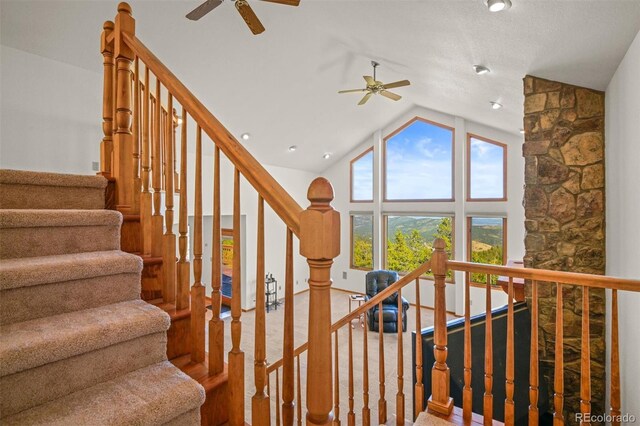 stairs featuring hardwood / wood-style floors, ceiling fan, and high vaulted ceiling