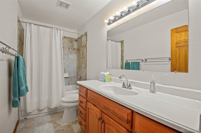 full bathroom featuring shower / bath combo with shower curtain, vanity, and toilet