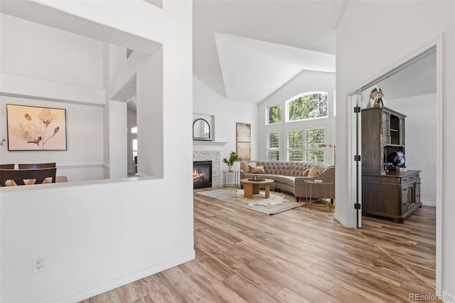 9576 E 147th Pl, Brighton, CO 80602 - living area featuring wood finished floors, a stone fireplace, and high vaulted ceiling