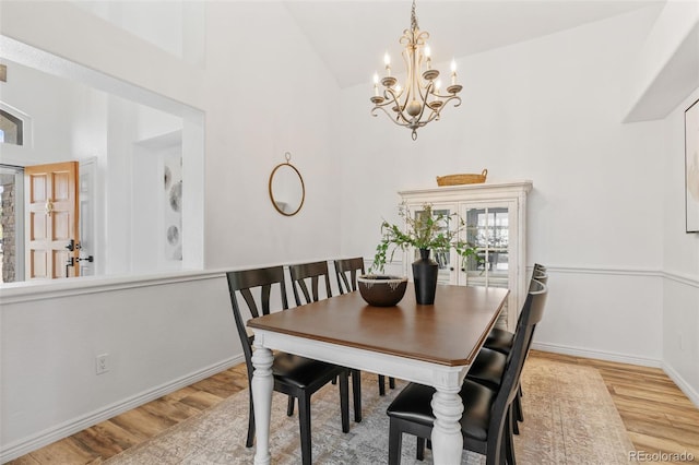 9576 E 147th Pl, Brighton, CO 80602 - dining area with light wood-style floors, a chandelier, and high vaulted ceiling